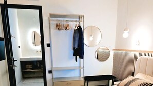 Een slaapkamer met een bed, nachtkastjes, een kledingkast, een spiegel en een hanglamp.