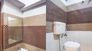 Un baño con lavamanos, inodoro y baldosas de pared a cuadros.