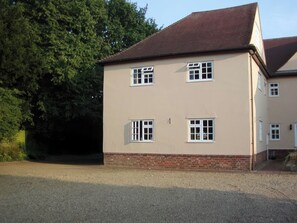 A two-story building with a brick base and a flat roof. - No 1 The Martins (Reydon)