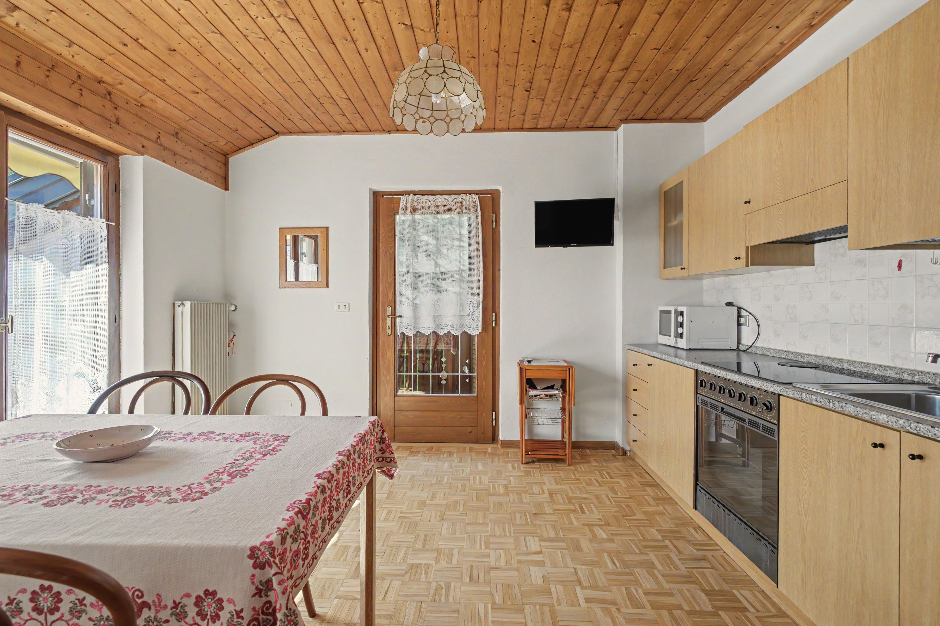 Una cocina con armarios de madera, un microondas, una estufa y un lavamanos.