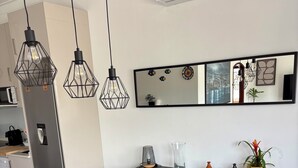Eine moderne Küche mit Kühlschrank, Mikrowelle und Esstisch mit blauen Stühlen.