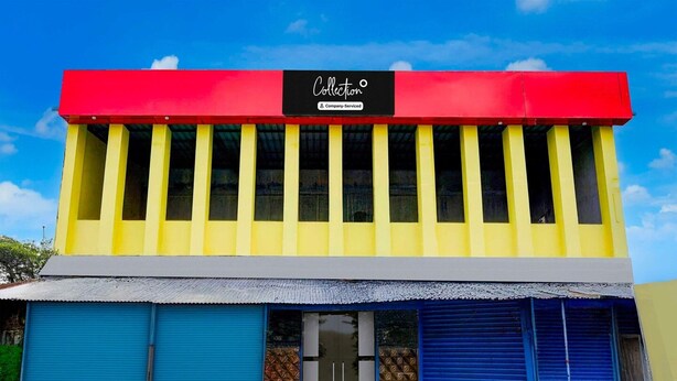 A two-story building with a red and yellow facade, a black sign reading 'Collection,' and blue garage doors.