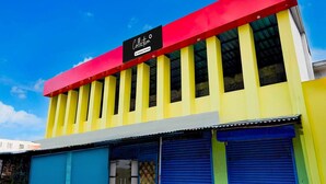 A building with a red roof, yellow walls, and blue garage doors.