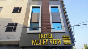 Et hotel kaldet 'Hotel Valley View' med skilte for klimaanlæg, restaurant, festlokale og børnefødselsdag.