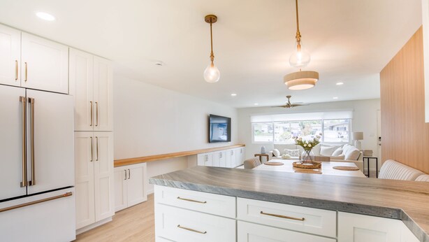 A modern kitchen with white cabinetry, a marble countertop, and pendant lighting. - Charming Encinitas Retreat Near Local Beaches (Encinitas)