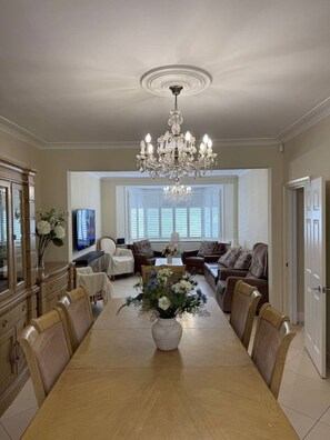 A dining room with a chandelier, a long table, and chairs. - Bright Quiet Garden View Room (London)