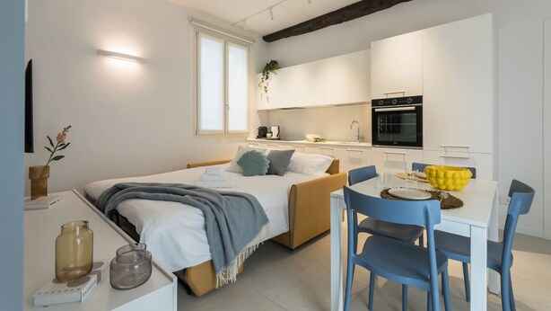 Une chambre à coucher moderne avec un lit, une table de chevet et une fenêtre.