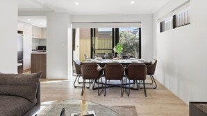 Un soggiorno moderno con zona pranzo, divano e tavolino in vetro.
