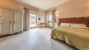 A bedroom with a bed, a desk, and a wardrobe.