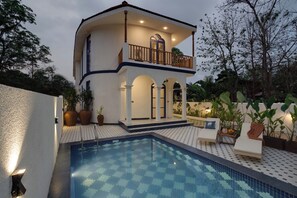 A two-story building with a balcony, a swimming pool with tiled patterns, and potted plants. - Staymaster Cove Villa - 3BR Private Pool (Parra)