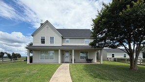 A two-story house with a front porch, a visible chimney, and a large tree to the right. - Picturesque Ranch House Retreat/Cattle Ranch/Twin Lakes/First Monday (Canton)