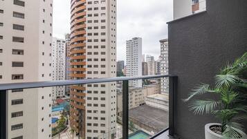 A high-rise building with a curved facade, a rooftop pool, and a view of other buildings.