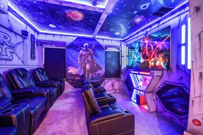 Ein Zimmer im Star-Wars-Design, inklusive einer Wandmalerei eines Charakters, einer Gaming-Ecke mit Neonlichtern und einer Reihe von Ledersesseln.