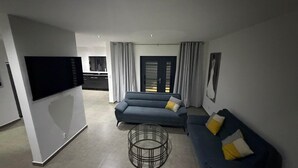 Una sala de estar moderna con un sofá, una mesa de centro y un televisor.