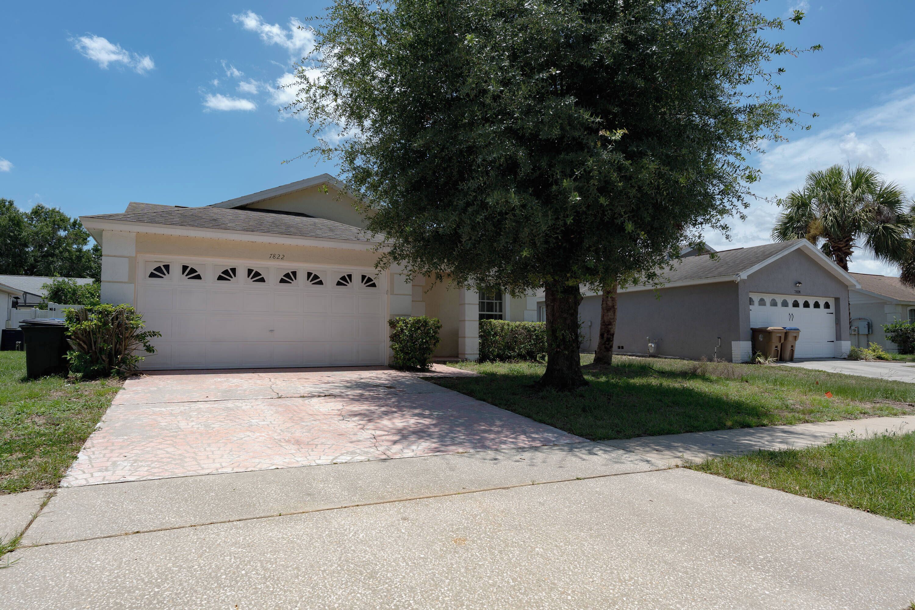 A residential house with a garage, a driveway, and a well-maintained lawn.