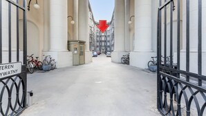 Um corredor com colunas, uma placa com seta vermelha e bicicletas estacionadas nas laterais.