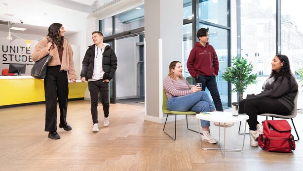A modern interior with a reception desk, large windows, and a seating area. - Unite - Harriet Martineau - Birmingham (Birmingham)