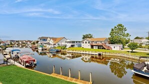 A waterfront property with a dock, houses, and a calm water body. - Keen-Wik on the Bay - 38138 Keenwik Rd (Selbyville)