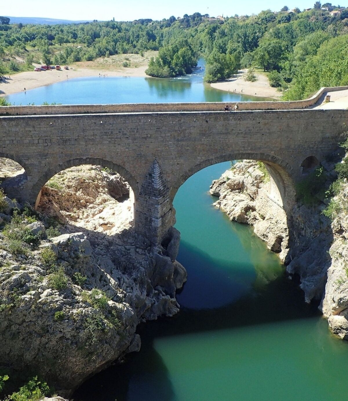 Eine Steinsaule über einem Fluss mit freiem Blick auf die umliegende Landschaft.