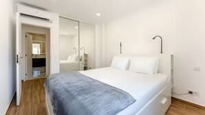 A bedroom with a bed, a wardrobe, a mirror, and a ceiling fan. - Casa Oceano Apartment with Wi-Fi and Air Conditioning (Armação de Pêra)