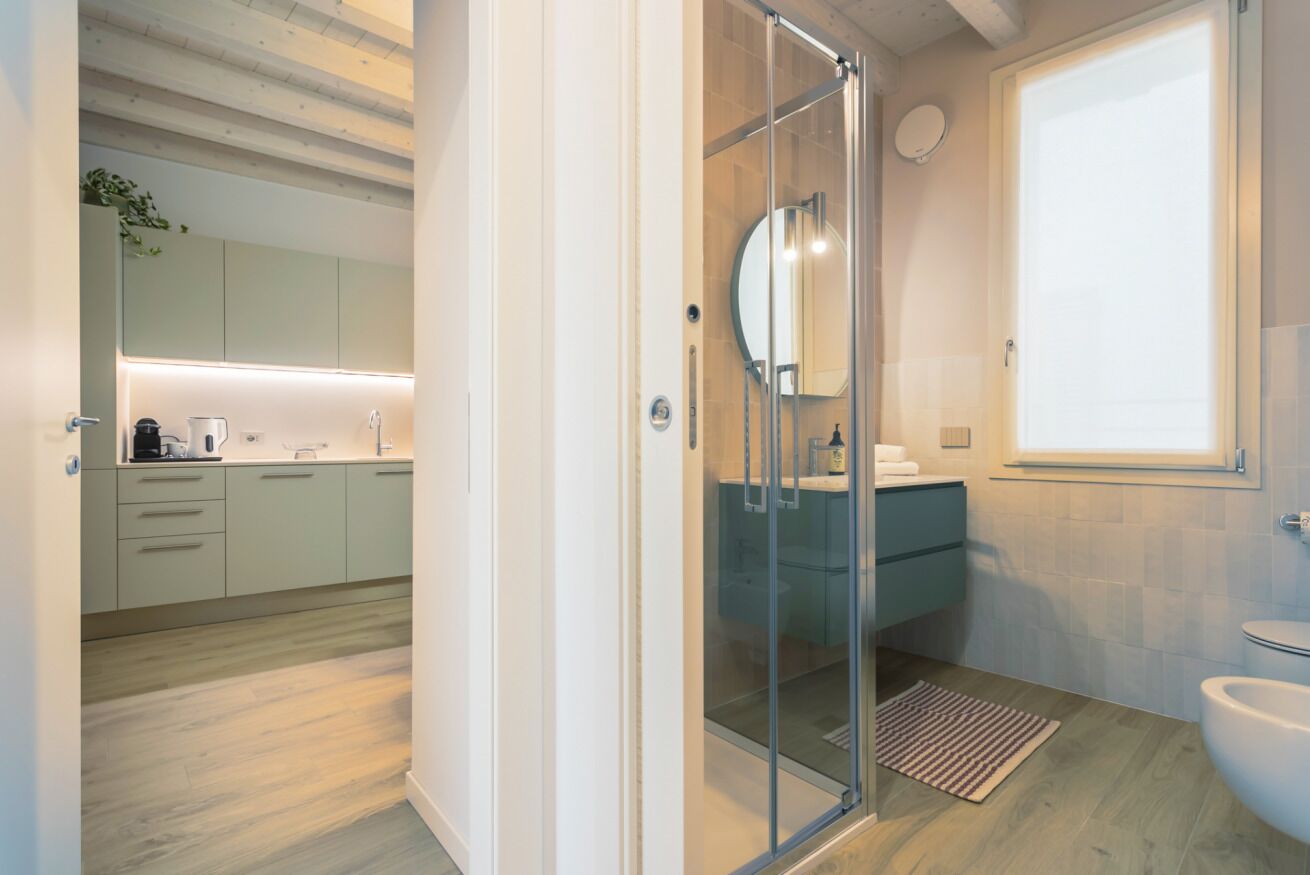 Un baño moderno con cabina de ducha de vidrio, lavamanos y retrete.