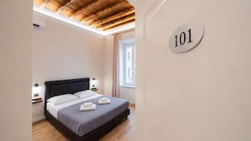 A bedroom with a bed, a headboard, bedside tables, a window, and a wall-mounted sign with the number 101.