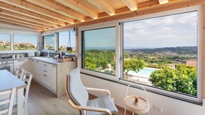 Una cocina moderna con ventanas amplias, una zona de comedor y vistas a un paisaje.