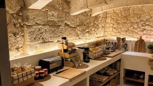 Una cocina con paredes de piedra, una encimera con varios electrodomésticos y estanterías.