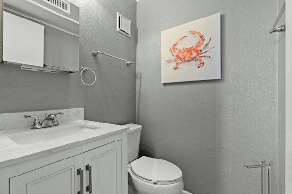 Une salle de bain avec un lavabo blanc, des toilettes et un porte-serviettes.