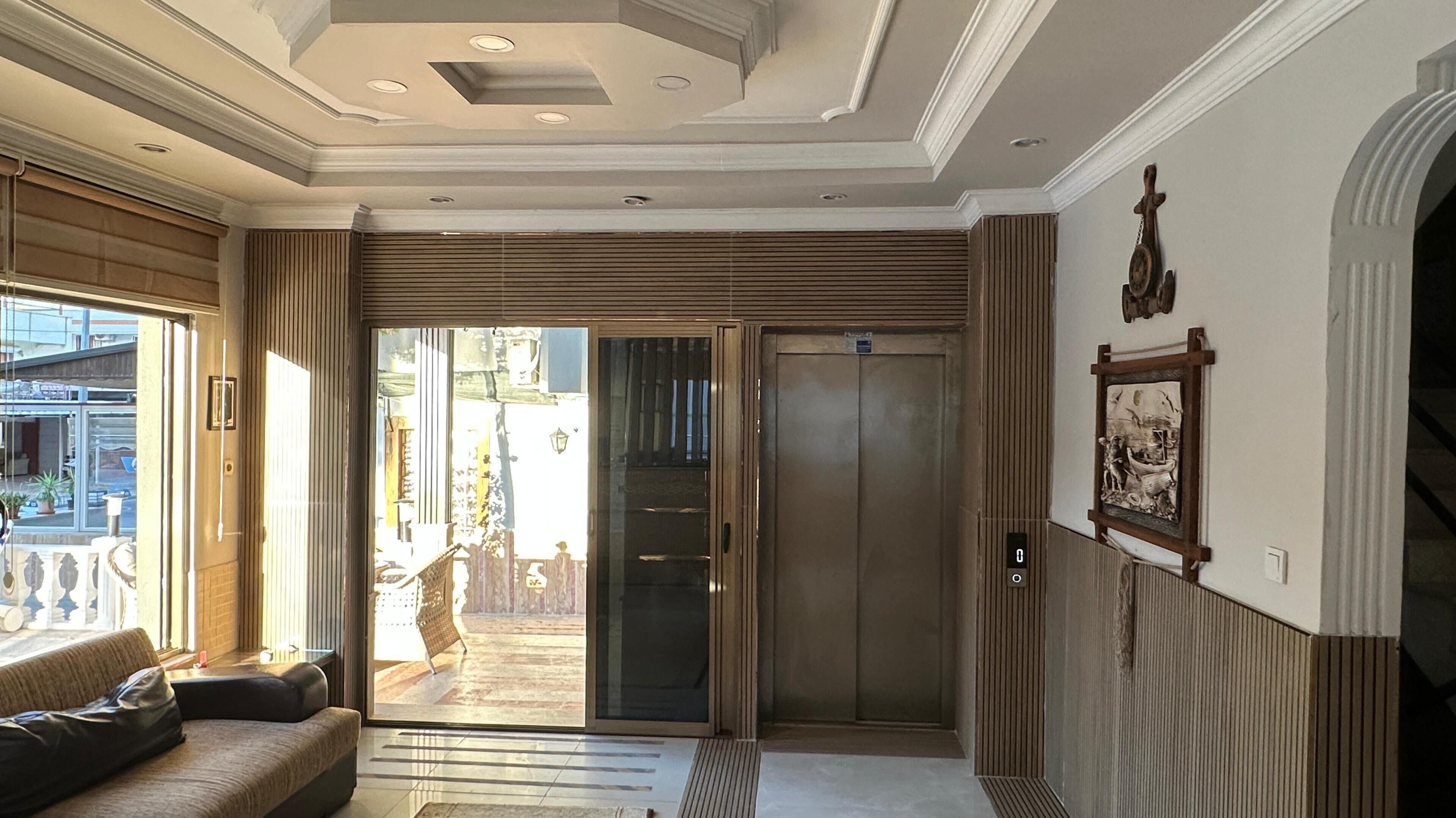 A modern interior with a sliding glass door leading to a balcony, a sofa, and a wall-mounted clock.