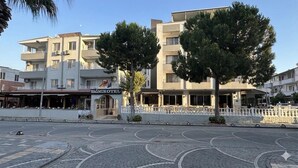 A hotel with a sign reading 'YAGMURO HOTEL,' a paved courtyard, and a white fence.