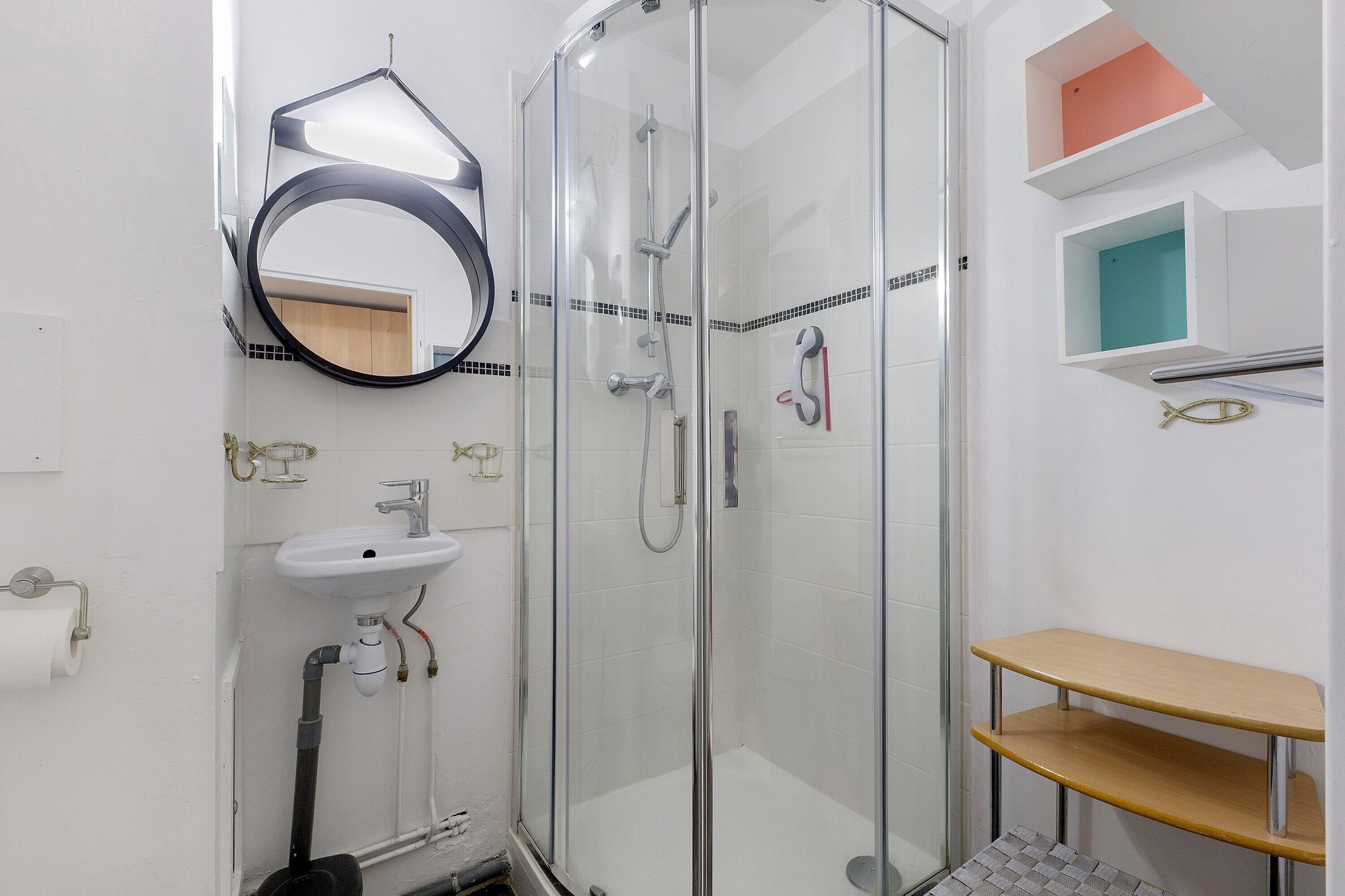 Une salle de bain moderne avec une douche à parois de verre, un lavabo et un miroir.