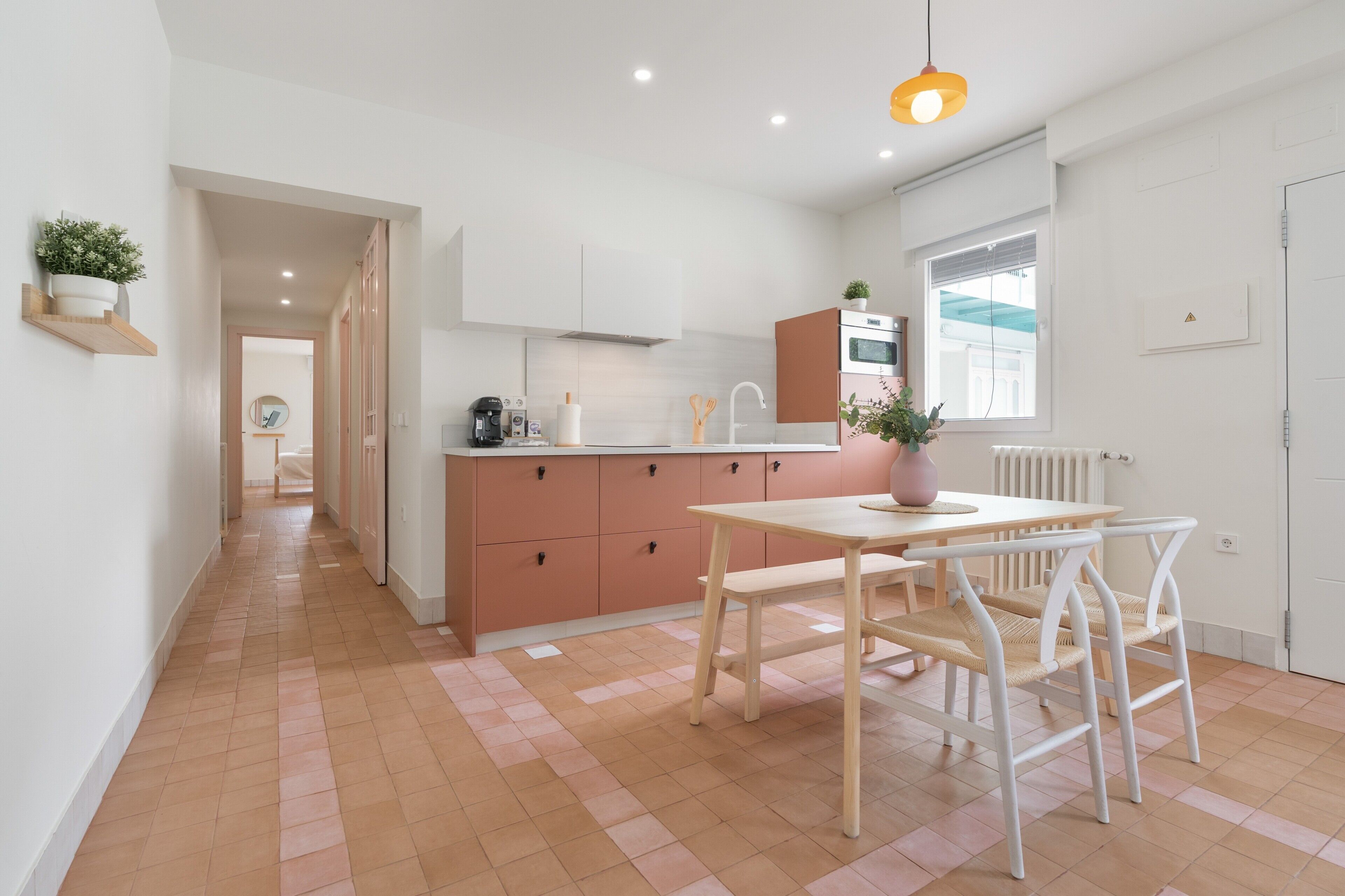 Een moderne keuken met een centraal eiland, een houten eettafel en stoelen.