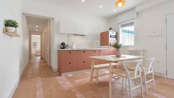 Een moderne keuken met een centraal eiland, een houten eettafel en stoelen.