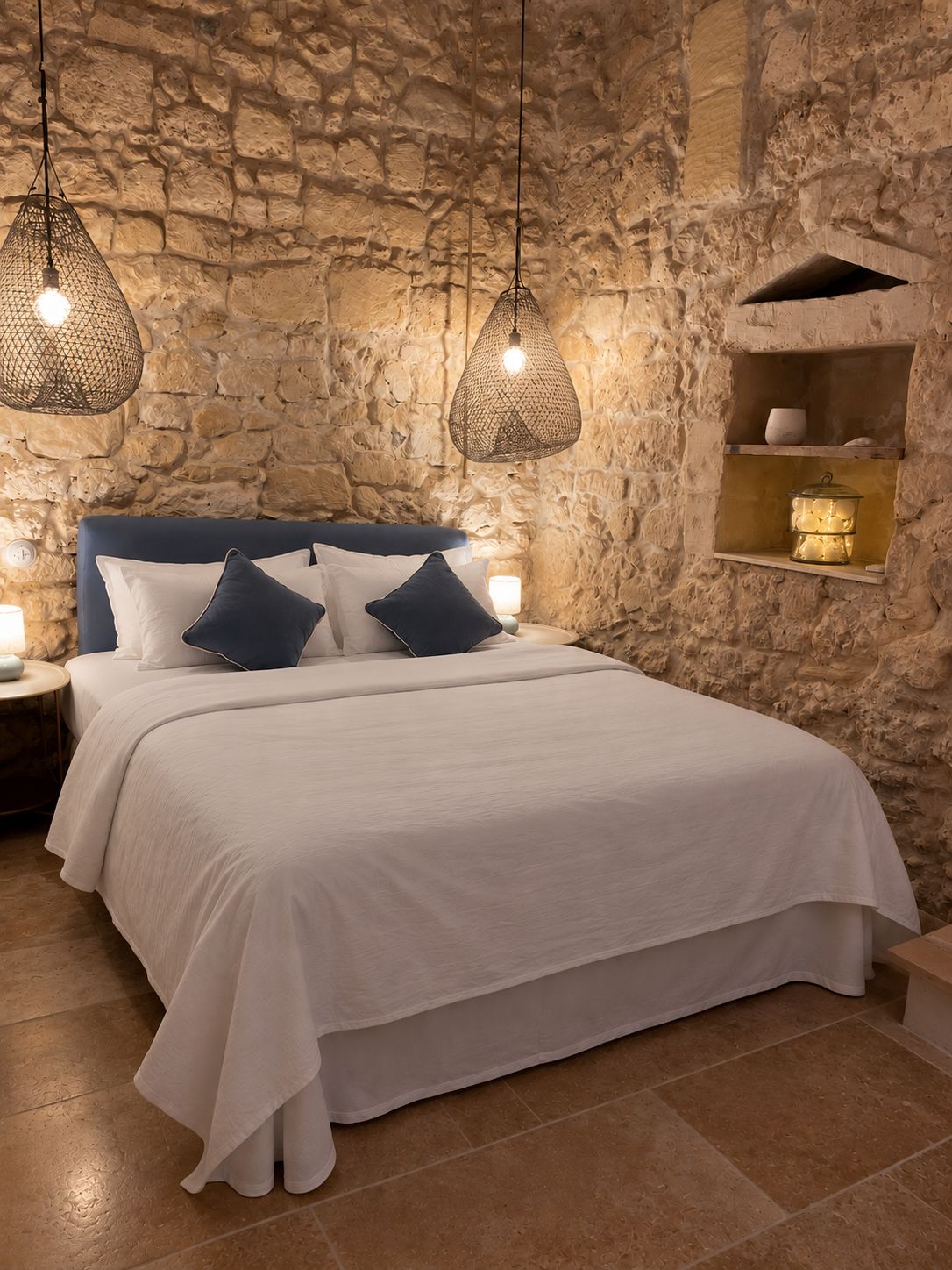 Charming stone-walled bedroom with warm lighting and cozy boutique style