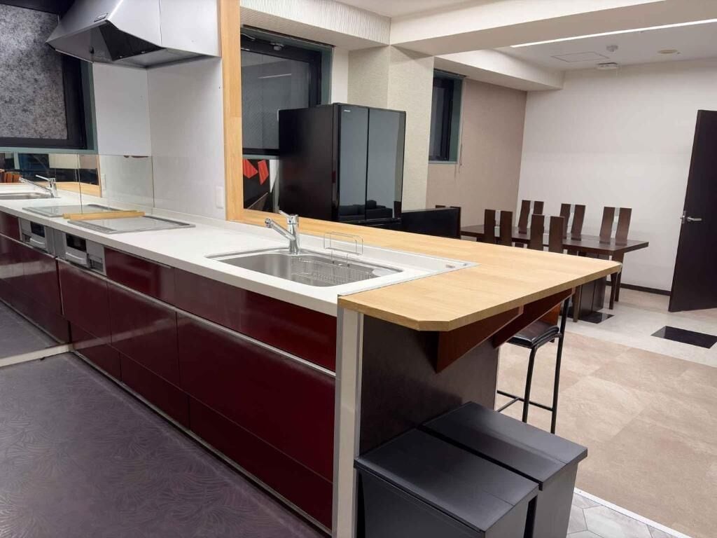 A modern kitchen with a central island, a built-in oven, and a large refrigerator.