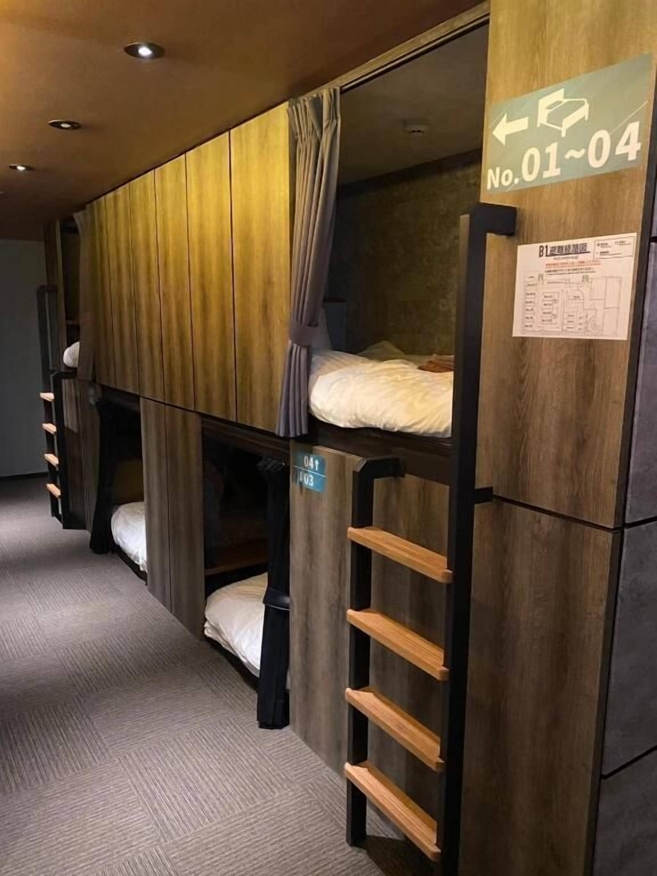 A bunk bed room with a wooden finish, a ladder, and a sign indicating room number 01-04.