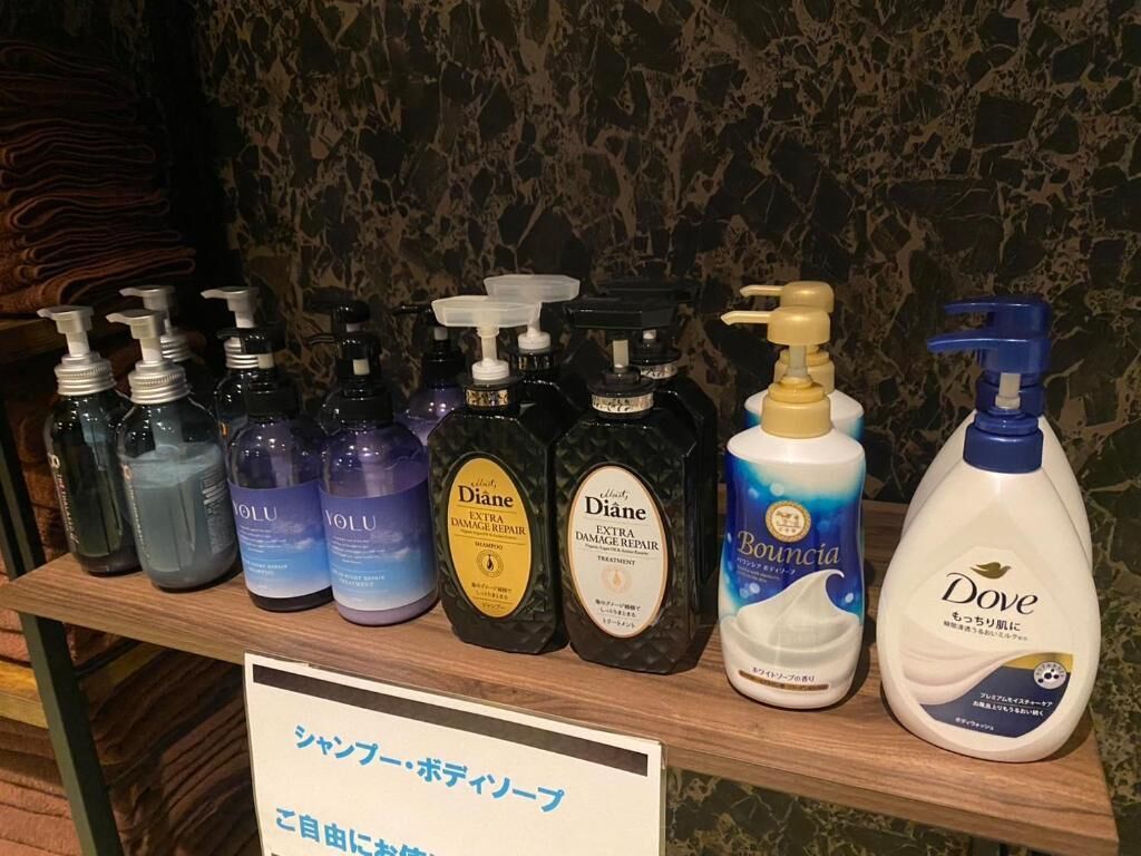 Une étagère contenant différentes bouteilles de savon liquide et de lotion pour les mains.
