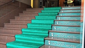 A staircase with green carpeted steps leading to a hotel entrance.