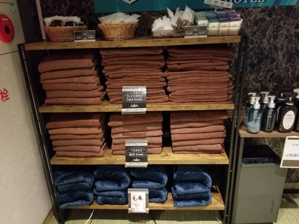 A display of folded towels with labels indicating their use, such as face and bath towels, in a hotel setting.