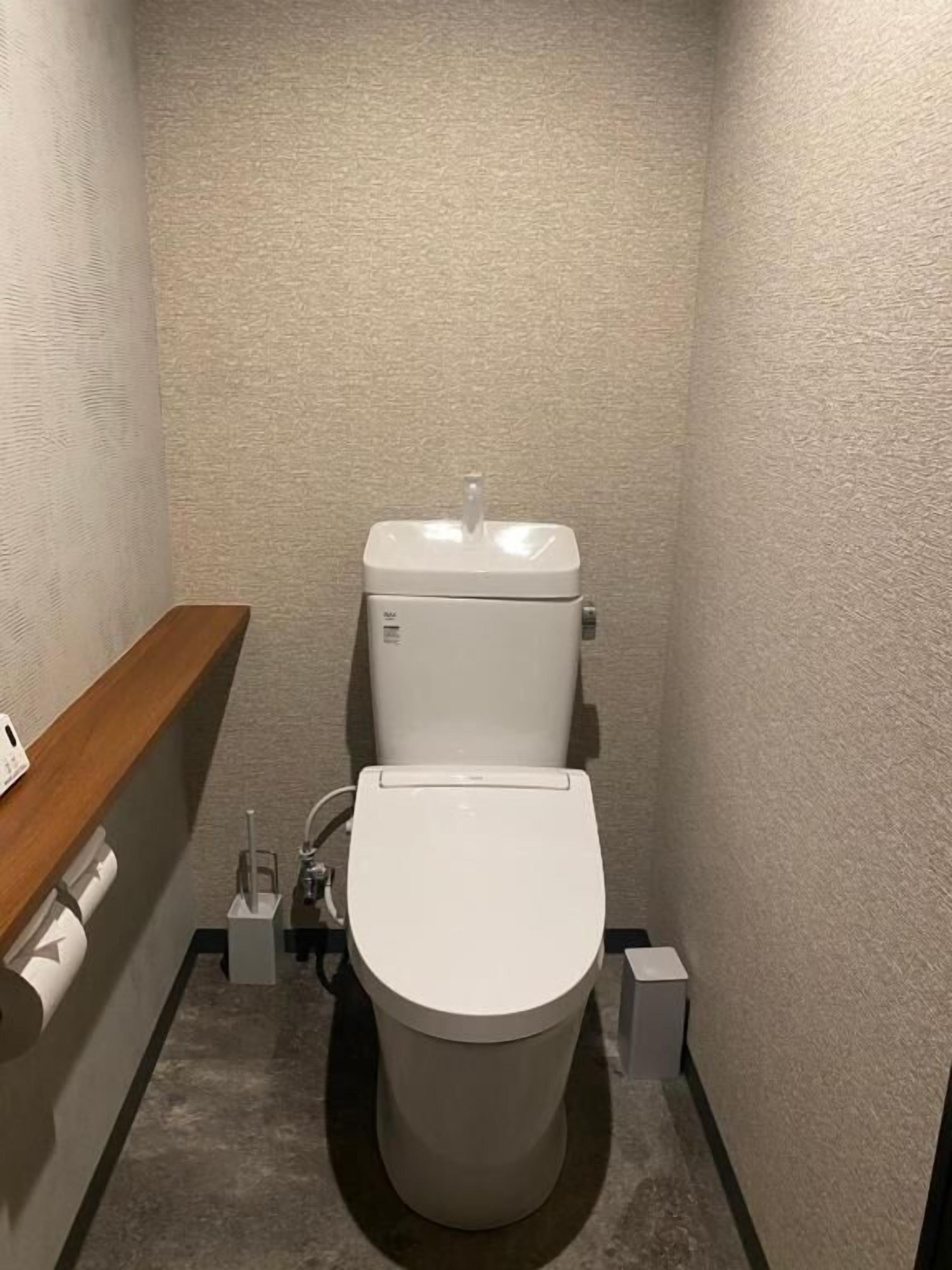 Um banheiro pequeno e moderno, com vaso sanitário, pia e espelho.