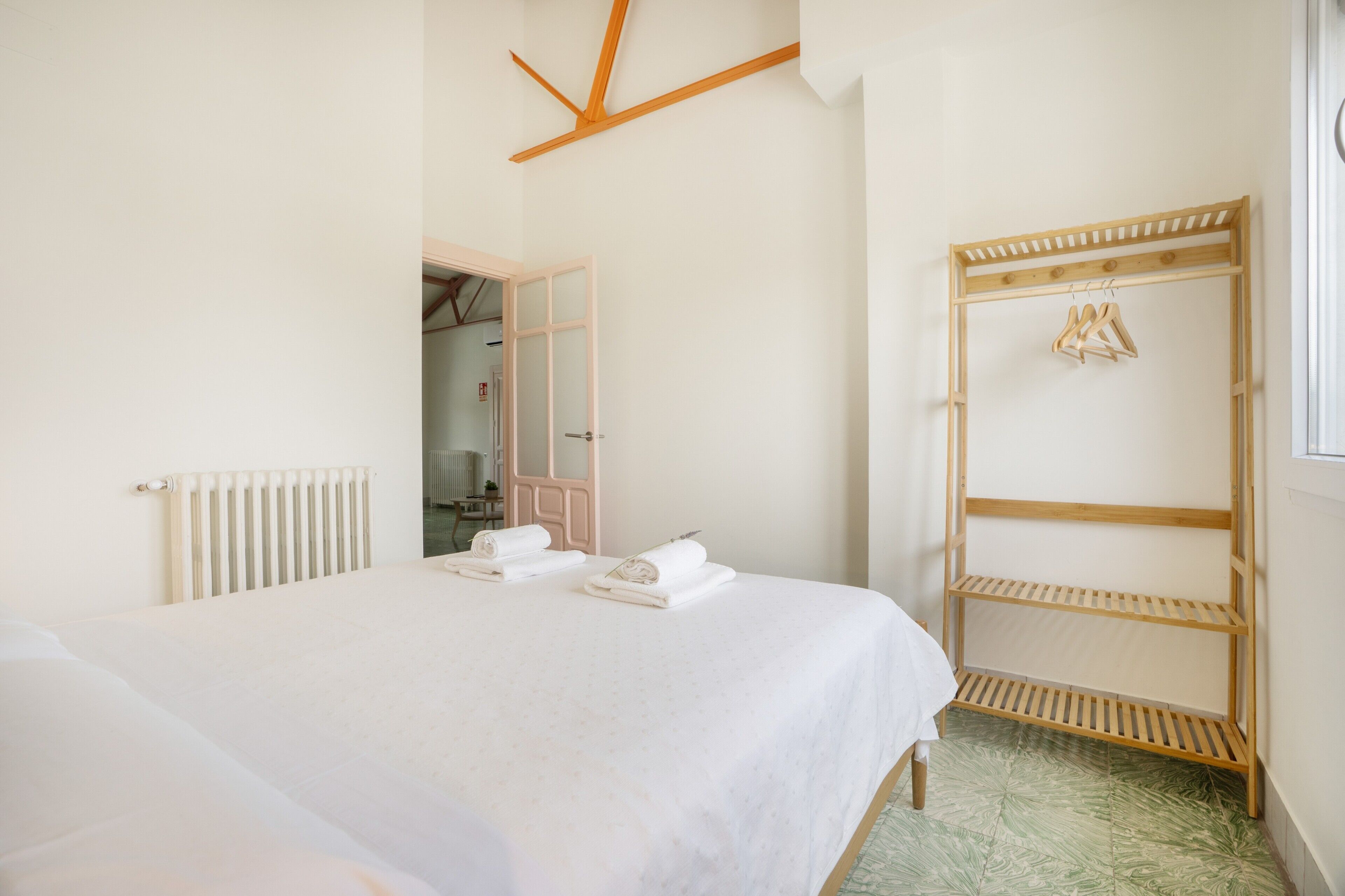 Un dormitorio con cama, armario de madera y radiador.