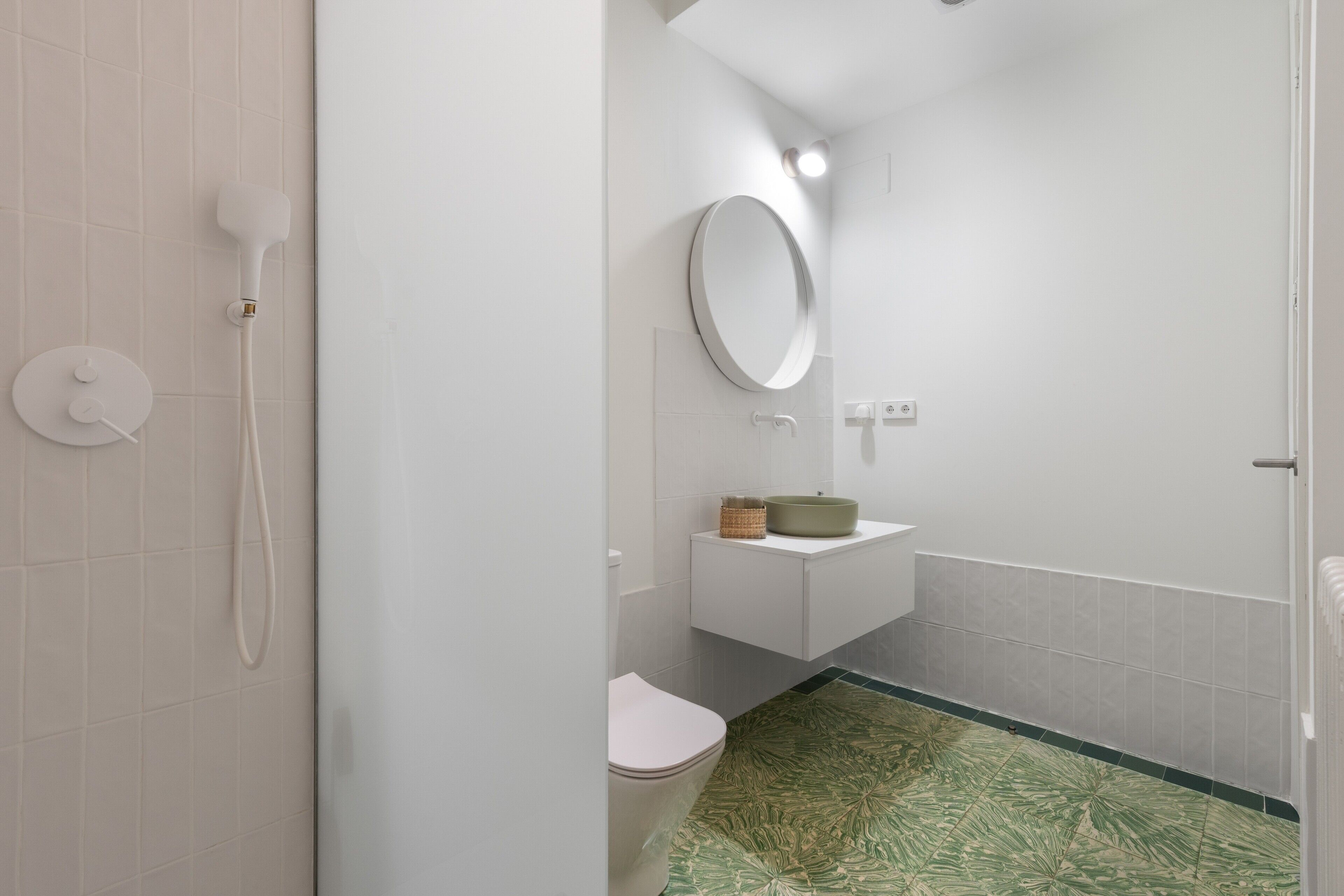 Une salle de bain équipée de toilettes, d’un lavabo, d’un miroir et d’une douche.
