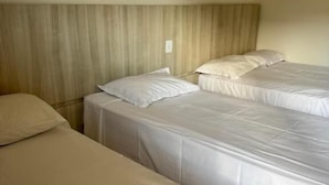 Habitación de hotel con dos camas individuales, cabecero de madera y una decoración en tonos neutros.