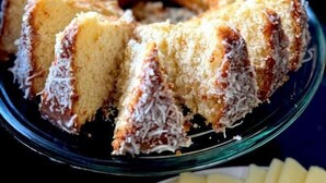 Un pastel Bundt con coco sobre un plato de vidrio.