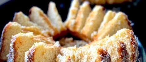 Un pastel Bundt con coco sobre un plato de vidrio.