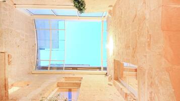 Ein Zimmer mit Oberlicht, großem Fenster und Holzboden.
