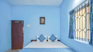 Une chambre à coucher avec un lit, une armoire, une fenêtre avec des rideaux et un tableau accroché au mur.