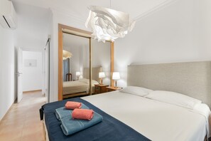 Ein Hotelzimmer mit Bett, Nachttischen, einem Spiegel und einer Tür.