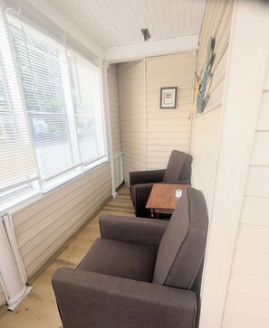 A corner room with a window, a framed picture on the wall, and a small table. - 1 bedroom pet friendly apartment on the first floor <br>- FREE parking<br>- ACs <br>- 7 minute walk from the beach.<br>- sleeps 3<br>- Queen bed and futon<br>- smart TV<br>- fast wifi<br>nroom before heading down to the beach! (Old Orchard Beach)